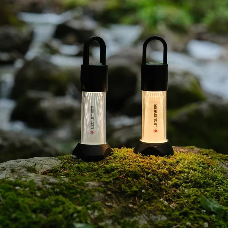 Camp lanterns glowing beside a creek